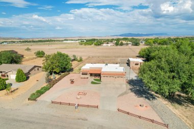 Uçsuz bucaksız tarlalar ve ağaçlarla çevrili güzel bir çiftlik evi manzarası geniş planlarını gözler önüne seriyor ve açık havayı davet ediyor..