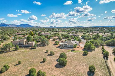 Arkaplanda dağınık ağaçlar ve parlak mavi bir gökyüzünün olduğu geniş ve geniş bir alan.