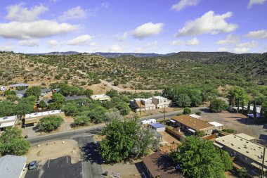 Gökyüzü manzaralı banliyö mahallesi kırmızı çatılı evlerle, ağaçlarla kaplı sokaklarla, küçük tepelerle çevrili.