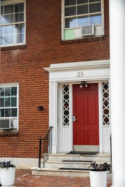 Dekoratif bitkileri olan samimi tuğladan ev, davetkar aksesuarları olan konut kaldırımı cazibesi