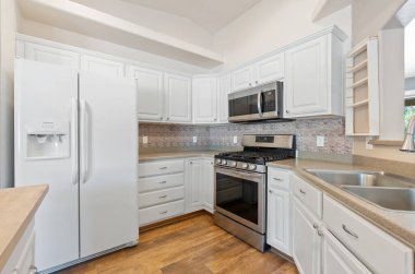 Beyaz dolaplar, paslanmaz çelik aletler ve geniş tezgahlar, yemek pişirmek ve eğlendirmek için mükemmel..