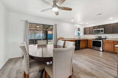 Modern aletlerin, ahşap dolapların ve aile toplantıları için ideal geniş bir yerleşim yerinin bulunduğu şık bir mutfak ve yemek alanı..