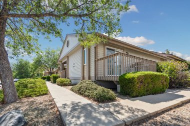 Zarifçe girişe giden nazik bir geçidi olan büyüleyici bir ev güzel çalılar ve uzun ağaçlarla çevrili.