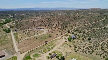 Uçan toprak yolların ve dağınık çiftliklerin üzerinde dairesel çayır manzarası var.,