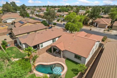 Güzel manzaralı arka bahçeye yerleştirilmiş havuzu olan ve rahatlamak için ideal bir evi gösteren bir hava manzarası.