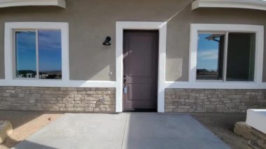 Taş cepheli ön giriş, merkezli kapı ve yan pencereler, beton iniş ve yol, kıtır kıtır.