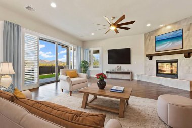 Şömine manzaralı ve verandaya açılan kapılar tarafsız kanepe, kahve masası, duvar...