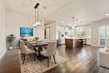 Ahşap döşemeli ve adalı açık yemek ve mutfak, Masanın üzerindeki kolye aydınlatma, tarafsız dekor