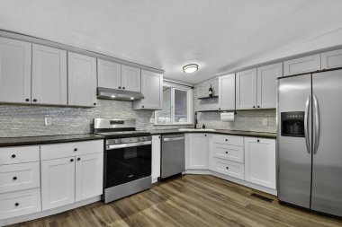 Paslanmaz Aletleri, Ahşap Döşemeleri, Lhaped Dolabı, Kuvars Tezgahları olan Parlak Beyaz Mutfak,