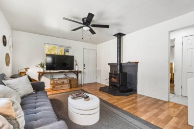 Odun sobası, kanepe, televizyon ve kırsal aksanlar, ahşap döşemeler ve desenli kilim sıcacık.