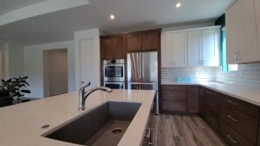 Ada lavabosu olan modern mutfak paslanmaz buzdolabı ve kuvars tezgahı, geniş açılı görünüm