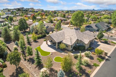 Döşeme çatıları, peyzajlı Xeriscape Yards ve dairesel garaj yolu olan Aerial Suburban Estate. Manikürlü Çalılar,