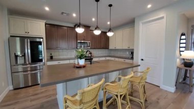 Rattan sandalyeli şık kahvaltı barı, kolye ışıkları, ada tezgahı, bitki süsü, günlük yemek.