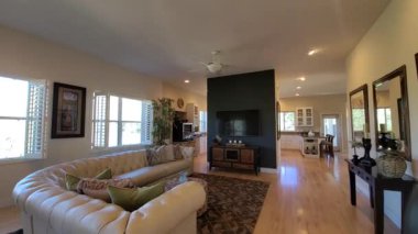 Oturma odasını şöminesi ve deri koltuğu olan, parke döşemeleri mutfağa dökülen, büyük televizyonlu.