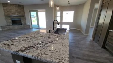 Şöminesi, siyah musluğu, granit tezgahı, ahşap dolabı ve kolyesi olan lüks mutfak adası.,