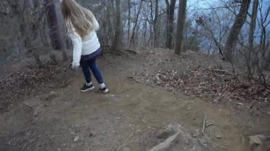 Beyaz ceketli bir kadın gür bir ormanı keşfeder, dolambaçlı yollarda yürürken huzurlu anları yakalar ve güzelliğin tadını çıkarır.