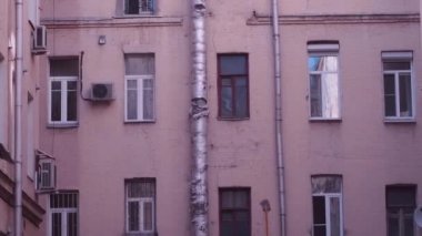 Eski bir duvar ile bir Downspout ve Saint Petersburg, Rusya'nın tipik iyi-avlu eski binada bir yangından sonra kirli pencere eşiği düşük açılı.