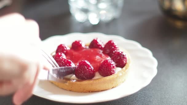 Cortar una primera pieza de una tarta de frambuesa con un tenedor y un cuchillo, comer postre, primer plano extremo en cámara lenta — Vídeos de Stock