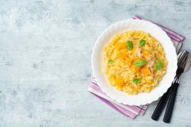 Parmesan peynirli balkabaklı risotto ve çimento kaplı fesleğen yaprakları. Üst görünüm, alanı kopyala.
