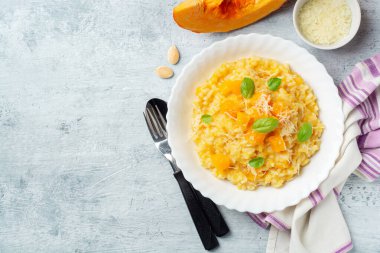 Parmesan peynirli balkabaklı risotto ve çimento kaplı fesleğen yaprakları. Üst görünüm, alanı kopyala.