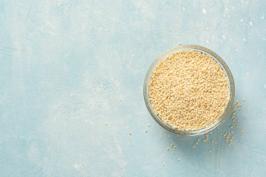 Beton arka planda cam kasede beyaz susam tohumları. Üst görünüm, alanı kopyala.