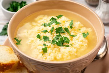 İtalyan stracciatella yumurtalı çorba parmesan peyniri ve sade ahşap arka planda maydanoz. Seçici odak.