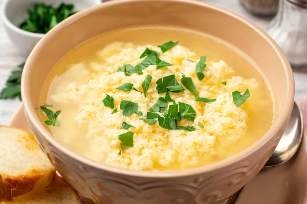 İtalyan stracciatella yumurtalı çorba parmesan peyniri ve sade ahşap arka planda maydanoz. Seçici odak.
