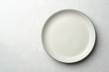Gri beton arka planda boş bir plaka. Üst görünüm, alanı kopyala.
