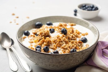Yoğurtlu granola ve yaban mersinli beton arka planda. Seçici odak.