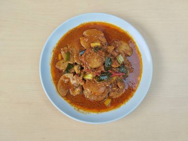 Semur jengkol ya da ahşap masa arkaplanlı baharatlı köpek meyvesi, Endonezya yemeği. Düz yatıyordu 