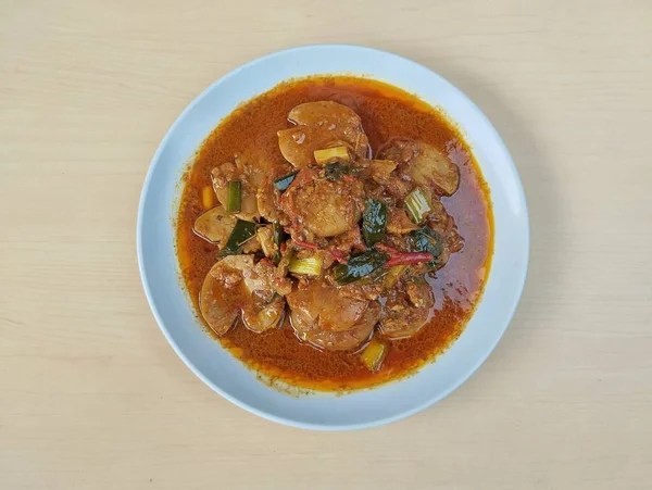 Semur jengkol ya da ahşap masa arkaplanlı baharatlı köpek meyvesi, Endonezya yemeği. Düz yatıyordu 