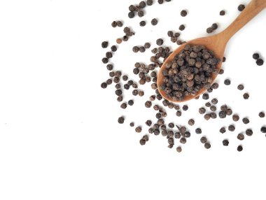 Tahta kaşıkta karabiber yığını beyaz arka planda izole edilmiş, düz uzanmış. 