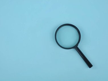 Açık mavi arka planda siyah büyüteç. Arama, keşif, soruşturma, araştırma, denetim ve çözüm bulma kavramları için mükemmel.