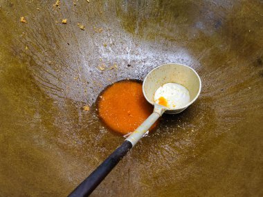 Keçi köri sosu pişirmek için kullanılan büyük bir tencerede büyük kepçe.