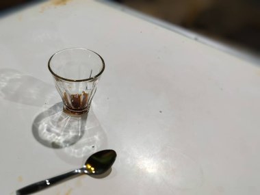 Masanın üzerinde kaşıkla boş bir kahve fincanını kapat.