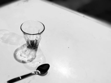 Siyah ve beyaz arka planda izole edilmiş kaşık ile boş kahve fincanı yakın plan