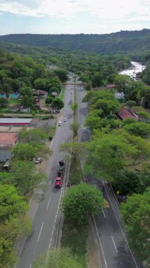 Doğanın ortasındaki sanik otoyol, dağlarla ve ağaçlarla çevrili asfalt yol, manzarayla harmanlanmış otoban manzarası. Yüksek kalite 4k görüntü