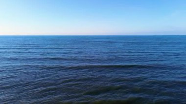 İnsansız hava aracından, minimalist mavi okyanustan ve insansız hava aracından, sakin okyanus suyundan ve insansız hava aracından görünen uçsuz bucaksız ufuktan görünen sonsuz ufka sahip derin mavi deniz. Yüksek kalite 4k görüntü