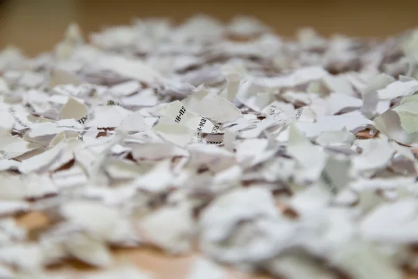 Scraps of torn paper on a brown table — Stock Photo, Image