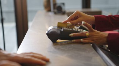 Müşteri otel resepsiyonunda kredi kartı terminalini kullanarak ödeme yapıyor, işlem sürecini kapatıyor