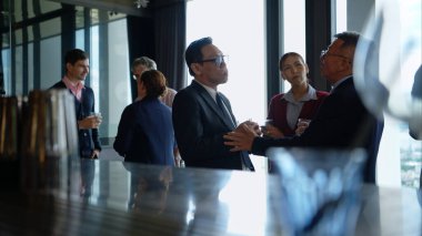 Modern bir ofis ortamındaki kurumsal bir etkinlikte iş dünyasından profesyoneller içki içip eğleniyorlar.