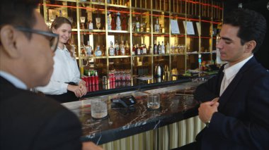 Modern bir barda müşterilere içki servisi yapan gülümseyen barmen.