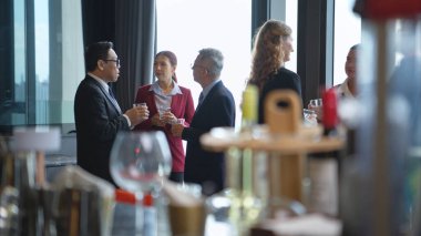 Modern bir ofis ortamındaki kurumsal bir etkinlikte iş dünyasından profesyoneller içki içip eğleniyorlar.