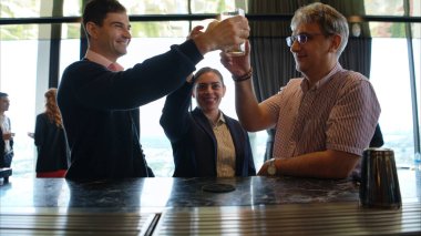 Modern bir barda müşterilere içki servisi yapan gülümseyen barmen.