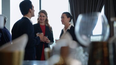 Modern bir ofis ortamındaki kurumsal bir etkinlikte iş dünyasından profesyoneller içki içip eğleniyorlar.