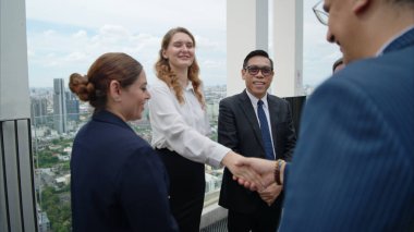 Modern bir çatıdaki açık hava toplantısında iş ekibi dizüstü bilgisayarda birlikte çalışıyor.