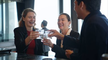 Modern bir barda müşterilere içki servisi yapan gülümseyen barmen.