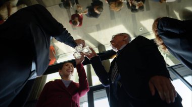 Modern bir ofis ortamındaki kurumsal bir etkinlikte iş dünyasından profesyoneller içki içip eğleniyorlar.