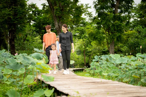 Asyalı bir aile, şehrin ortasında büyük bir çiçek bahçesinde büyük bir çiçek bahçesinde geziniyor.