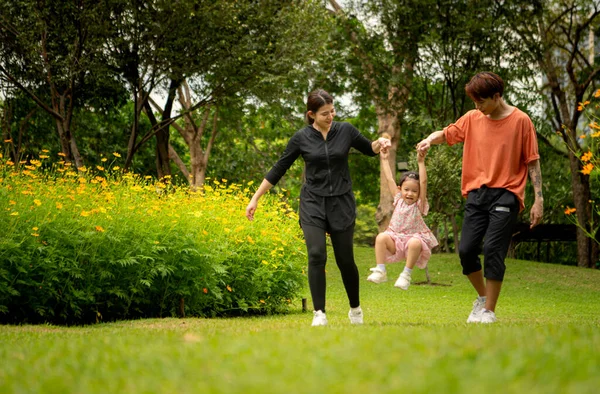 Ebeveynler ve kızları şehrin ortasındaki büyük bir çiçek bahçesinde geziniyorlar.